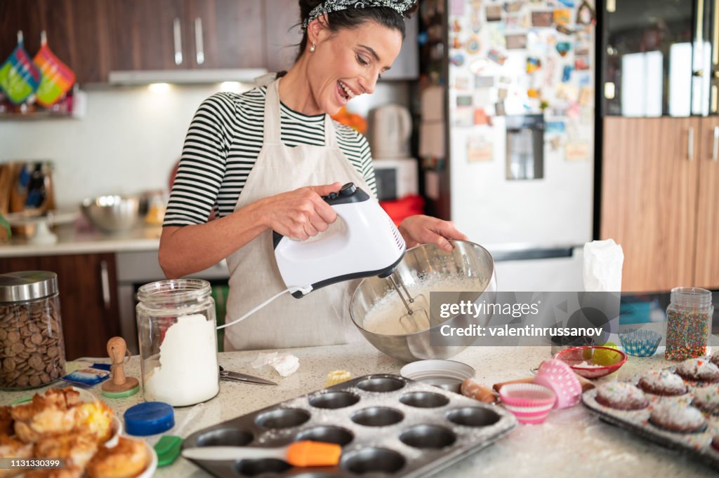 Pastelero mujer haciendo deliciosa crema para cupcakes