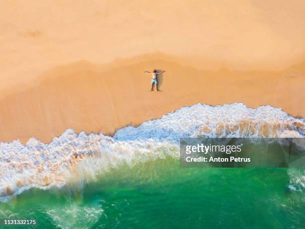 the guy lies on a sandy beach on a tropical island. drone view - sri lankan culture stock pictures, royalty-free photos & images