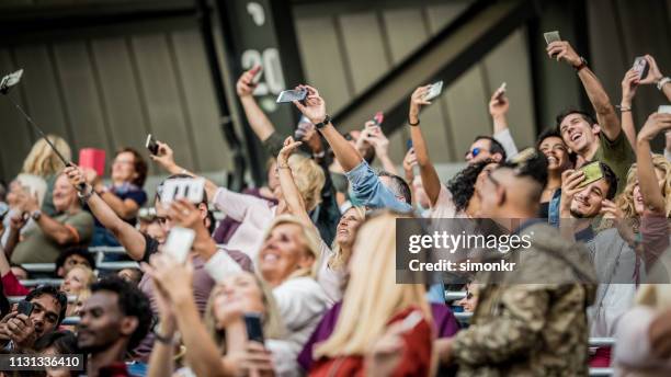 zuschauergruppe jubelt im stadion - many people stock-fotos und bilder