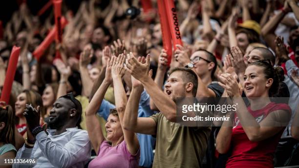 spectators cheering in stadium - crowd cheering stock pictures, royalty-free photos & images