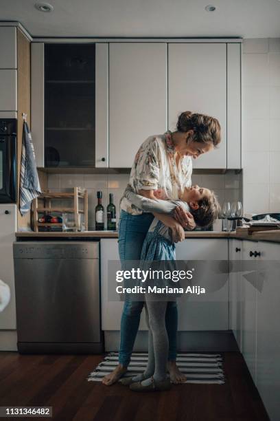 mother and daughter bonding - frau offenes lächeln küche stock-fotos und bilder