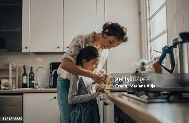 mother showing daughter how to peel an apple - vie réelle photos et images de collection