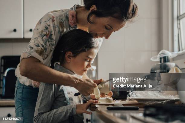 mother showing daughter how to peel an apple - mother and child cooking stock pictures, royalty-free photos & images