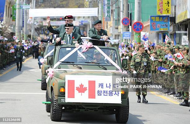 This picture taken on April 24, 2011 shows Korean War veterans from Canada being greeted by South Koreans in a parade during a ceremony to...