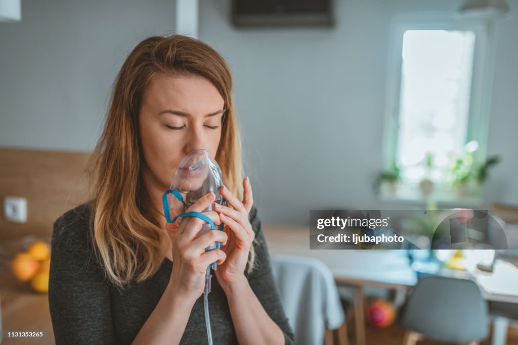 Young woman using an asthma inhaler