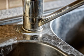 Close-up of a kitchen sink with lime scale