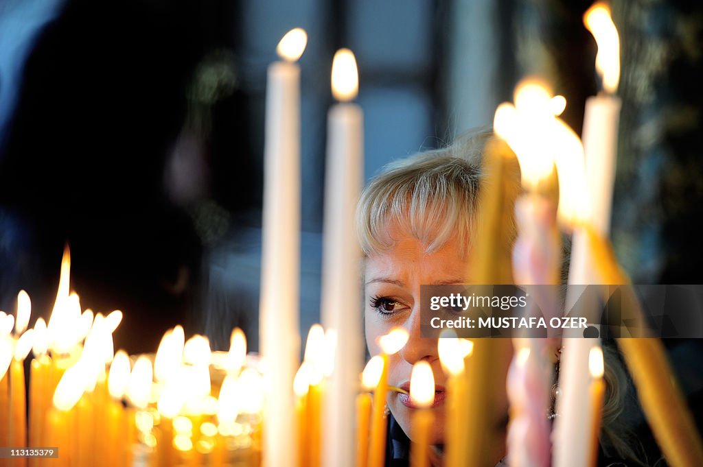 A Greek Orthodox woman lights a candle d