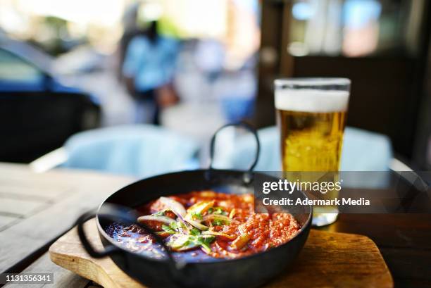 indian curry dish & beer on an outdoor table - curry stock pictures, royalty-free photos & images