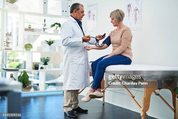 we'll have to do something to get this blood pressure down - doctor looking down stock pictures, royalty-free photos & images
