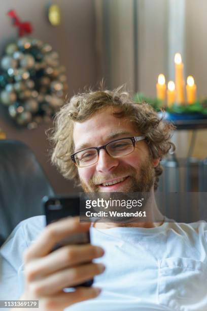 portrait of happy man with smartphone at home at christmas time - chat noel stockfoto's en -beelden