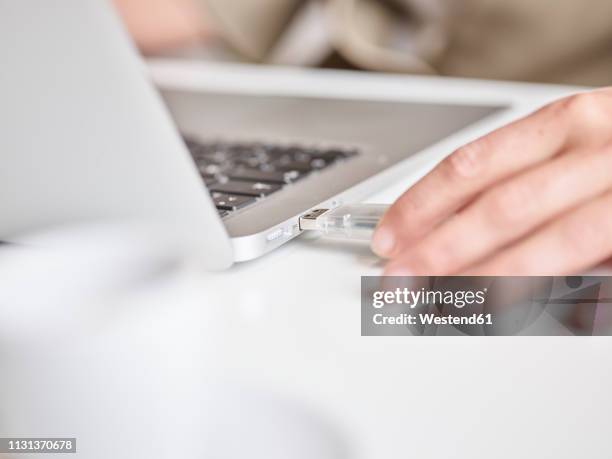 close-up of woman connecting usb stick to laptop - pen drive - fotografias e filmes do acervo