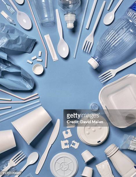 single-use plastic objects arranged around an empty circle. - biodegradable plastic stock pictures, royalty-free photos & images