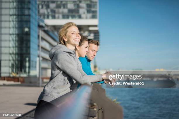 friends leaning on railing at the riverside after training - aachen 2017 prize of north rhine westphalia stockfoto's en -beelden