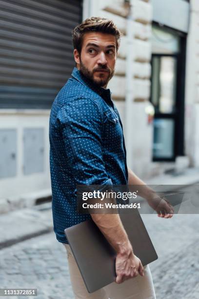 portrait of businessman with laptop on the street watching something - pompadour imagens e fotografias de stock