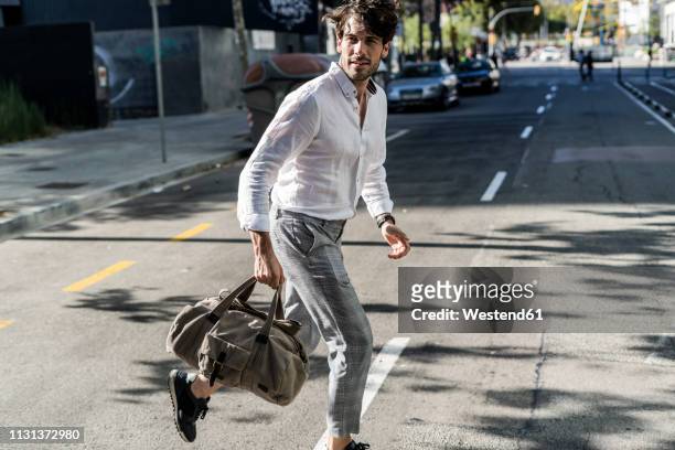 young man in the city on the go crossing street - man running city fotografías e imágenes de stock