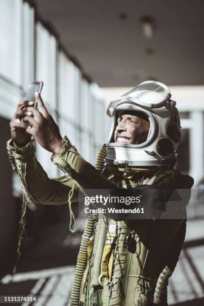 happy astronaut in spacesuit using smartphone - facebook check in stock pictures, royalty-free photos & images