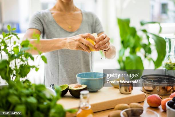 woman preparing healthy food in her kitchen - detox stock-fotos und bilder