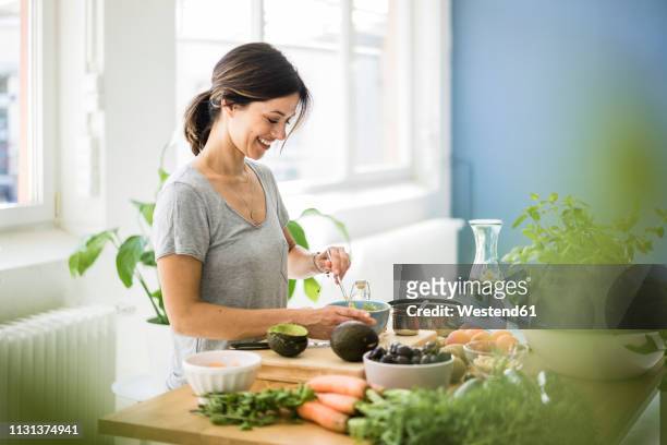 woman preparing healthy food in her kitchen - beauty balance stockfoto's en -beelden
