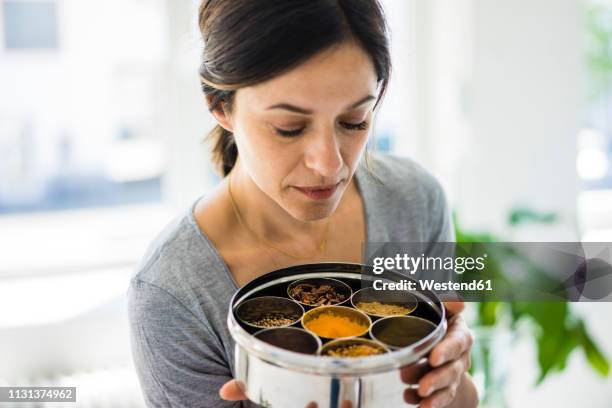 woman holding tin box with choice of spices - cardamom stock pictures, royalty-free photos & images