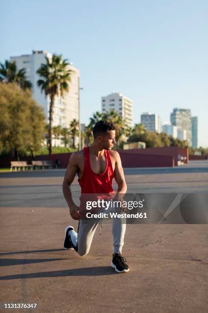 fit man warming up before workout, doing lunges - ausfallschritt stock-fotos und bilder