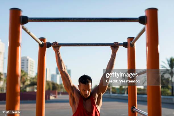 fit man working out in climbing parcour, doing pull ups - barra horizontal imagens e fotografias de stock