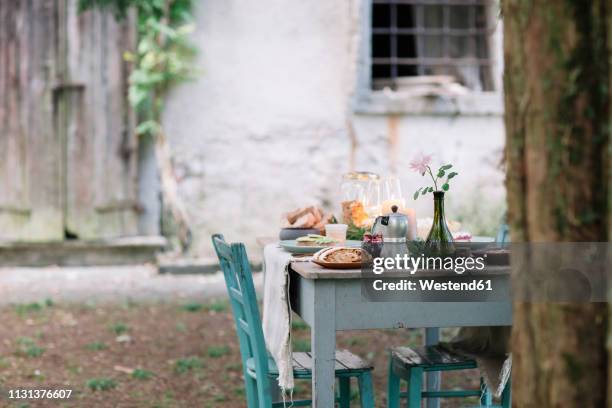 laid garden table with candles next to a cottage - villetta foto e immagini stock