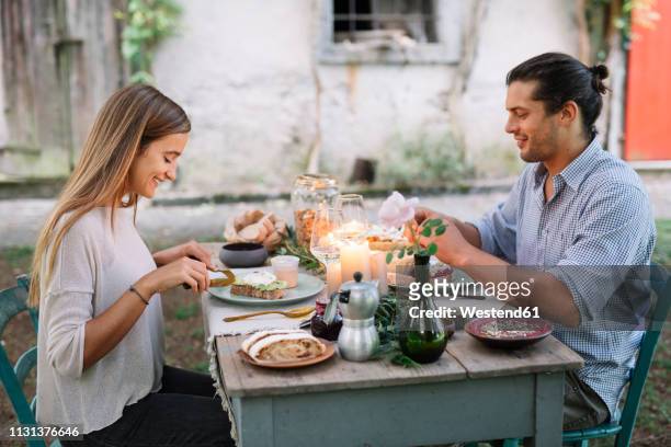 couple having a romantic candelight meal next to a cottage - italien food stock-fotos und bilder