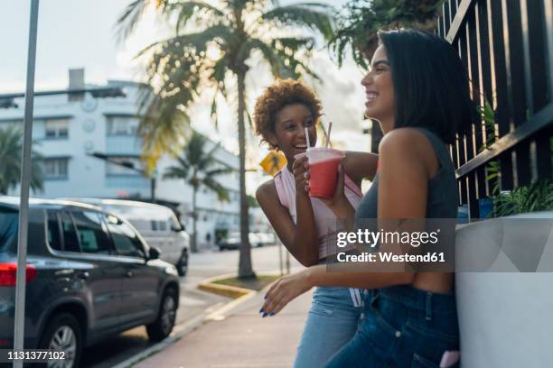 usa, florida, miami beach, two happy female friends having a soft drink in the city - drinking soda in car stock pictures, royalty-free photos & images
