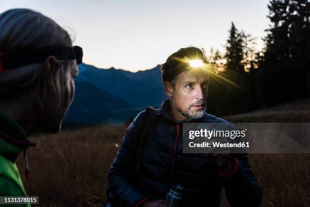 couple hiking at night, wearing head lamps - hoofdlamp stockfoto's en -beelden