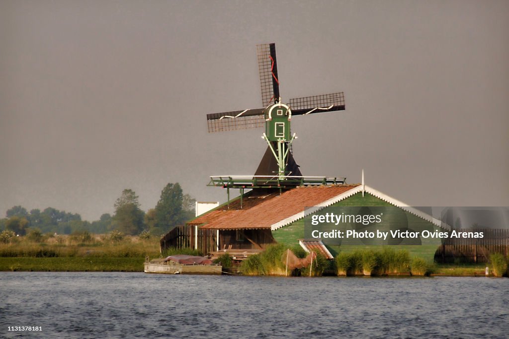 Traditional Dutch landscape. Wooden windmill and house in Zaanse Schans, Netherlands
