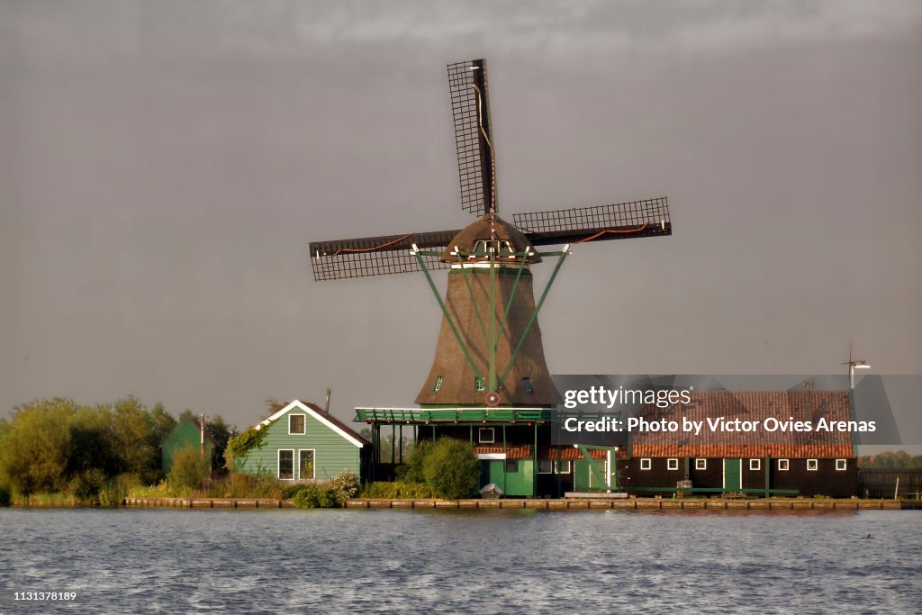 Traditional Dutch landscape. Windmill and wooden houses in Zaanse Schans, Netherlands