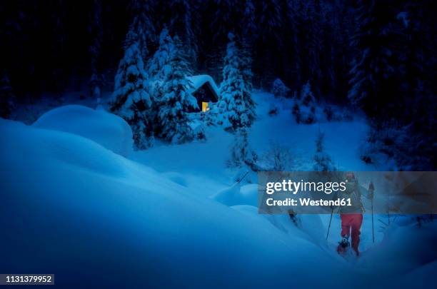 austria, salzburg state, snowshoeing, woman near hut at night - woman snow outside night stock pictures, royalty-free photos & images