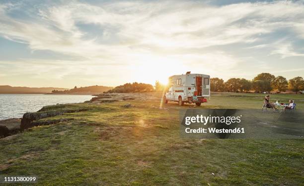 chile, talca, rio maule, camper at lake with family having dinner at sunset - distant family stock pictures, royalty-free photos & images