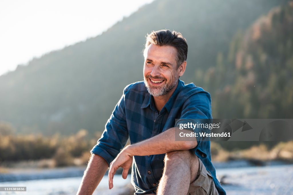 Mature man camping at riverside