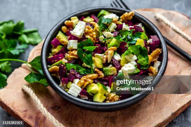 bowl of beetroot salad with avocado, feta, walnuts and parsley - avocado salad stock pictures, royalty-free photos & images