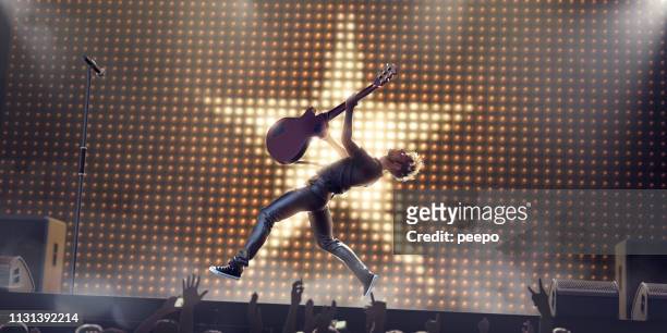 rock ster in mid air jump met gitaar op het podium - popmuzikant stockfoto's en -beelden