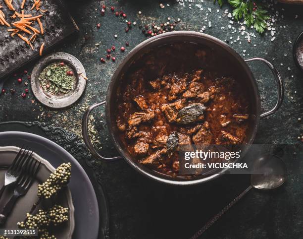 meat stew in cooking pot on dark rustic kitchen table background - stuvning bildbanksfoton och bilder