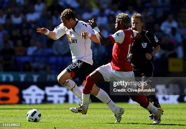 Alexandre Song of Arsenal competes with Johan Elmander of Bolton Wanderers during the Barclays Premier League match between Bolton Wanderers and...