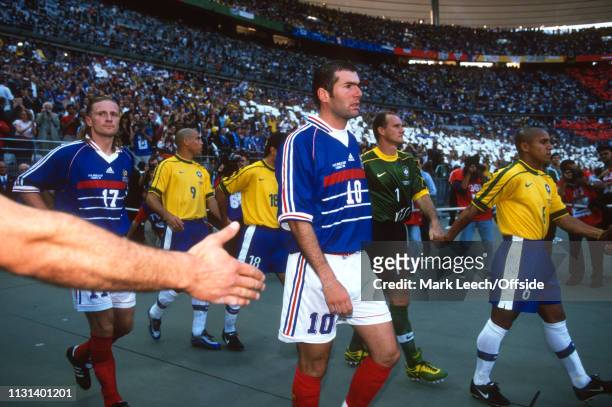 July 1998 - FIFA World Cup - Final - Stade de France - Brazil v France - Zinedine Zidane of France walks past a fans out streched hand on his way to...