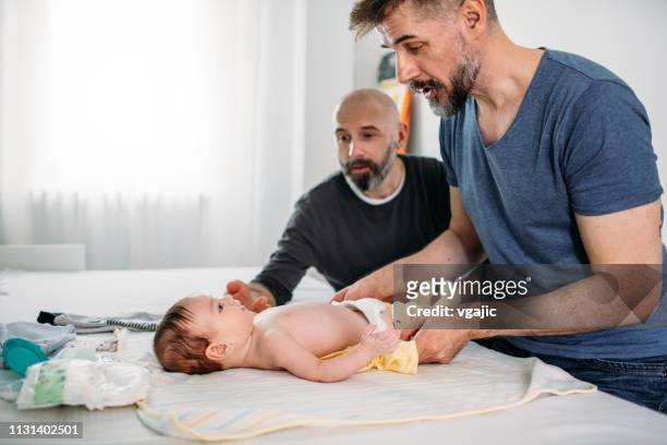 gay dads - changing nappy stock pictures, royalty-free photos & images