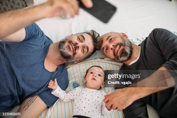 schwule dads - couple playful bedroom stock-fotos und bilder