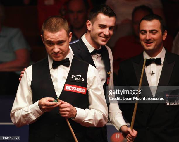 Stephen Hendry of Scotland looks to play a shot in the round two game against Mark Selby of England puts his hands on his sholder on day nine of the...