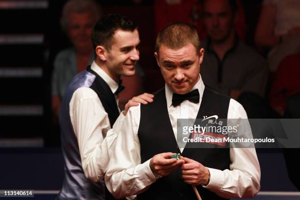 Stephen Hendry of Scotland looks to play a shot in the round two game against Mark Selby of England puts his hands on his sholder on day nine of the...