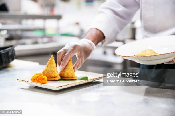 professioneller chefkoch platting die samosa mit chutney - food safety stock-fotos und bilder