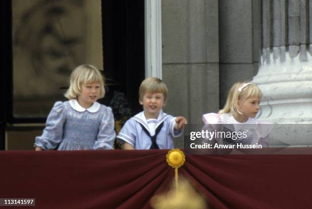 Prince William points from the balcony of Buckingham Place with his cousin Zara Phillips and Lady Davina Windsor following Trooping the Colour on...