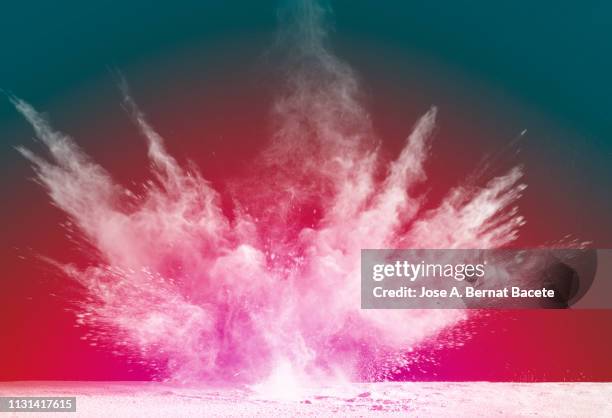 explosion by an impact of a cloud of particles of powder and smoke of color white on a red background. - 拆除 活動 個照片及圖片檔