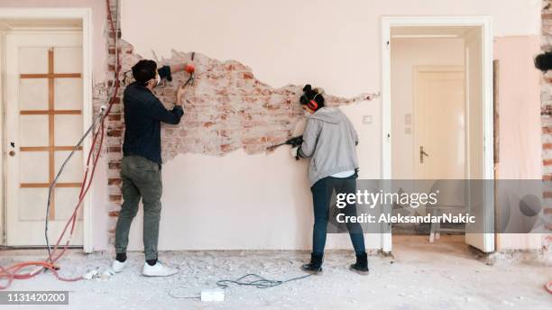 couple working on reconstruction of their apartment - rebuilding stock pictures, royalty-free photos & images