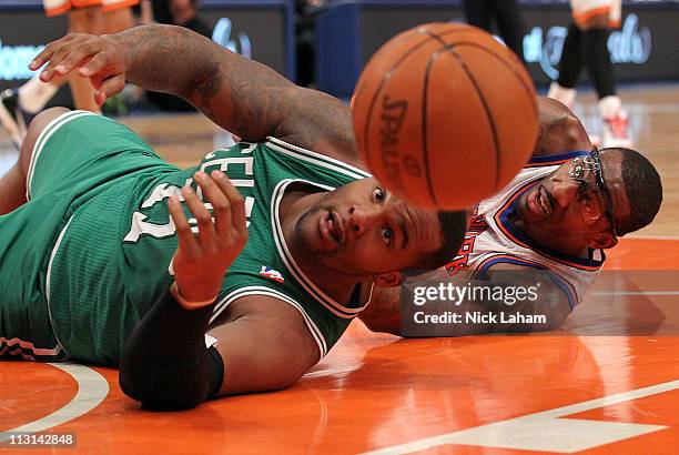 Glen Davis of the Boston Celtics and Amar'e Stoudemire of the New York Knicks reach for the ball as he bounces out of bounds in the first quarter of...