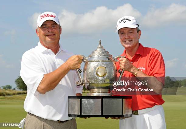 David Eger and Mark McNulty of South Africa pose with the tournament trophy after winning during the final round of the Legends Division at the...