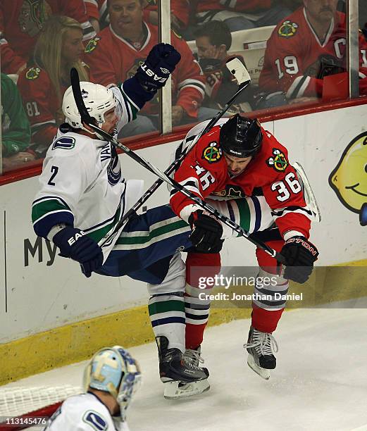 Dave Bolland of the Chicago Blackhawks hits Dan Hamhuis of the Vancouver Canucks in Game Six of the Western Conference Quarterfinals during the 2011...